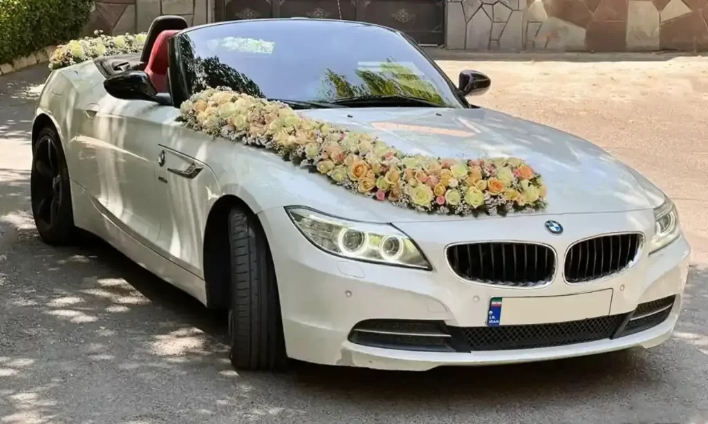 ماشین عروس بی‌ا‌م‌و بدون سقف با گل‌آرایی رز